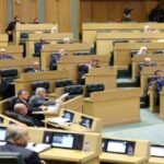 صورة لطلاب جامعيين يدرسون، مع إشارة رمزية لدعم المنح والقروض التعليمية.