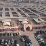 حافلات سياحية متوقفة أمام سوق الأحد بأكادير، تعكس تحديات مرآب السوق.