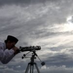 المملكة العربية السعودية تعلن الأربعاء أول أيام رمضان 1447هـ وسط تباين إقليمي 4 صورة لهلال رمضان يظهر في سماء صافية، يرمز لبداية الشهر الفضيل، مع إضاءة خافتة لمسجد في الأفق.