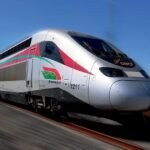 صورة لقطار البراق فائق السرعة في محطة مغربية خلال غروب الشمس، تعكس حركة النقل السككي في رمضان.