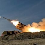 صورة لمدينة تل أبيب ليلاً مع دوي انفجارات أو صفارات إنذار، تعكس حالة التوتر الأمني.