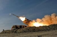 صورة لمدينة تل أبيب ليلاً مع دوي انفجارات أو صفارات إنذار، تعكس حالة التوتر الأمني.