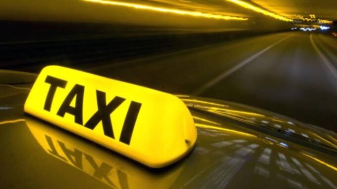 صورة لسيارة أجرة صفراء بجانب سيارة تابعة لتطبيق نقل ذكي في مدينة عمان، الأردن، ترمز إلى المنافسة بين القطاعين.