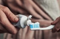 صورة لفرشاة أسنان جديدة ونظيفة بجانب فرشاة أسنان قديمة ومهترئة، مع التركيز على أهمية استبدالها بانتظام.