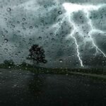 صورة توضيحية لأمطار غزيرة ورياح قوية في إحدى المدن المغربية، مع سماء ملبدة بالغيوم.