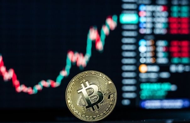 صورة توضيحية لعملة البيتكوين ووثائق قضية جيفري إبستين