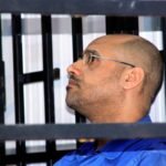 صورة لسيف الإسلام القذافي بلباس تقليدي يوقع وثائق ترشحه للانتخابات الرئاسية الليبية.