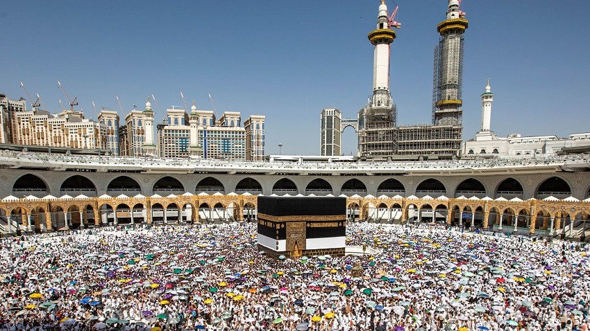 صورة لمجموعة من الحجاج أمام الكعبة المشرفة في مكة المكرمة
