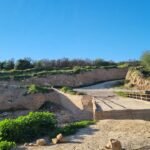 صورة لقنطرة مدمرة في واد بتارودانت، تظهر سيارات تحاول العبور وسط الحجارة والأوحال.