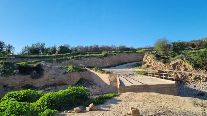 صورة لقنطرة مدمرة في واد بتارودانت، تظهر سيارات تحاول العبور وسط الحجارة والأوحال.