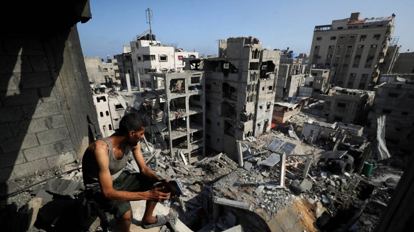 صورة لمدينة غزة تظهر آثار الدمار مع خلفية لمؤتمر دولي