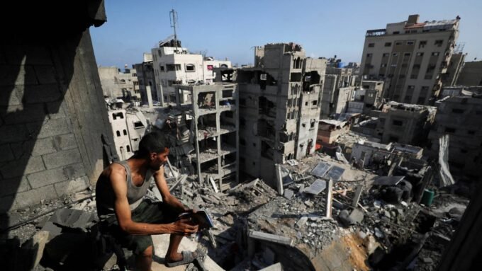 صورة لمدينة غزة تظهر آثار الدمار مع خلفية لمؤتمر دولي