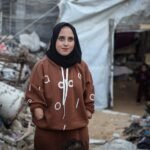 صورة تظهر نبال الحسي مع ابنتها ريتا أمام خيمتهم في مخيم جباليا للاجئين، تعكس معاناتهم اليومية.