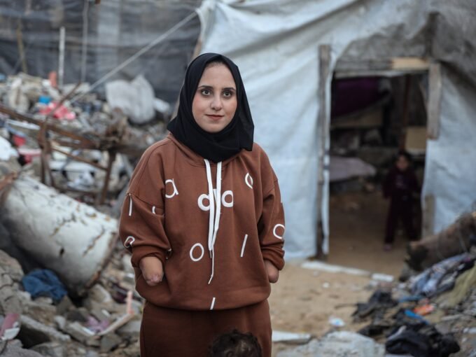 صورة تظهر نبال الحسي مع ابنتها ريتا أمام خيمتهم في مخيم جباليا للاجئين، تعكس معاناتهم اليومية.