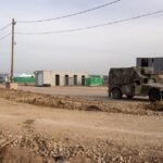 جنود إسرائيليون عند نقطة تفتيش في رفح، غزة، يقومون بالتدقيق في هويات الفلسطينيين وأمتعتهم.