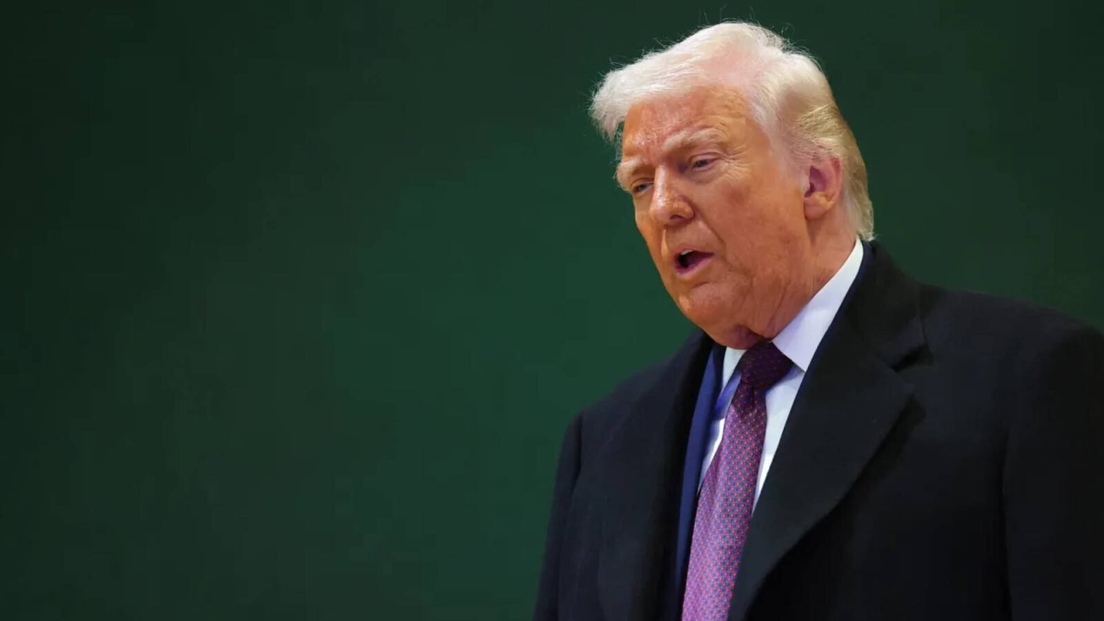 الرئيس الأمريكي السابق دونالد ترمب يتحدث عن ضرورة إنهاء حرب أوكرانيا، مع خلفية ترمز للمفاوضات.