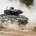 Défense européenne : Berlin presse Paris de revoir sa copie budgétaire 5 Le ministre allemand des Affaires étrangères, Johann Wadephul, s'exprimant lors d'une conférence de presse, avec des drapeaux allemand et français en arrière-plan, symbolisant les tensions diplomatiques sur les dépenses de défense.