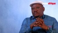 Jean-Marc Kabund s'exprimant lors d'une interview, avec un arrière-plan neutre, symbolisant son rôle d'opposant politique en RDC.