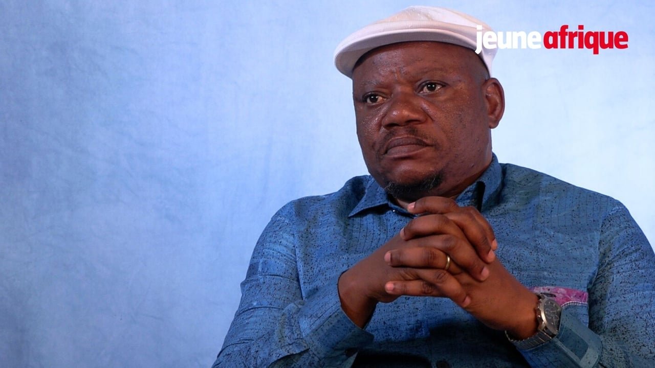 Jean-Marc Kabund s'exprimant lors d'une interview, avec un arrière-plan neutre, symbolisant son rôle d'opposant politique en RDC.