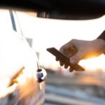 A modern smartphone displaying a digital car key interface, possibly with a BMW logo, symbolizing advanced vehicle access.