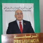 L'ambassadeur du Venezuela, Imad Saab Saab, s'entretenant avec le chef du Front Polisario, Brahim Ghali, dans les camps de Tindouf, avec des drapeaux en arrière-plan.