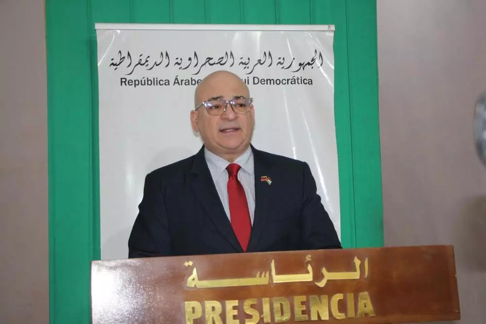 L'ambassadeur du Venezuela, Imad Saab Saab, s'entretenant avec le chef du Front Polisario, Brahim Ghali, dans les camps de Tindouf, avec des drapeaux en arrière-plan.