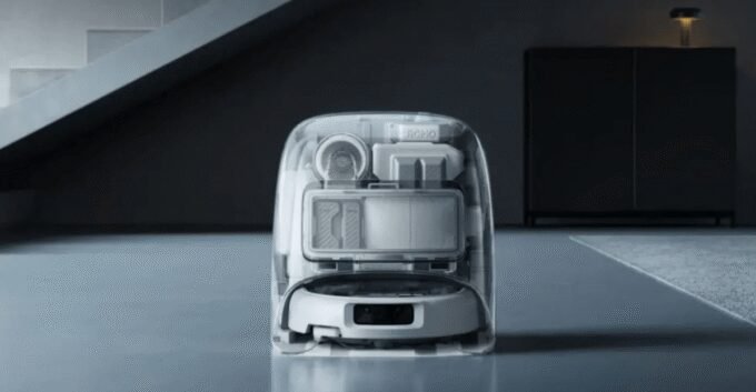 A DJI Romo robot vacuum in its translucent charging dock, highlighting its sleek design.