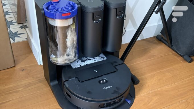 Dyson Spot+Scrub Ai, robot aspirateur laveur haut de gamme, posé sur un sol propre, mettant en avant son design futuriste et ses brosses de nettoyage.