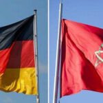 Drapeaux du Maroc et de l'Allemagne flottant côte à côte, symbolisant la force et la croissance de leur partenariat économique bilatéral.