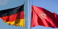 Drapeaux du Maroc et de l'Allemagne flottant côte à côte, symbolisant la force et la croissance de leur partenariat économique bilatéral.