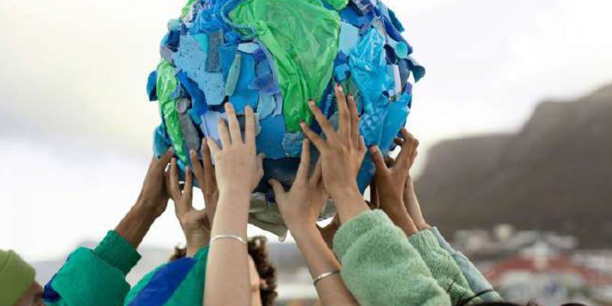 Une main tenant un globe terrestre miniature, symbolisant la protection de l'environnement et l'économie circulaire.