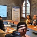 Un groupe de professionnels en discussion lors d'une session de formation sur la gouvernance d'entreprise familiale, avec des sourires et des gestes de collaboration, symbolisant le leadership intergénérationnel et la pérennité.