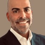 Florida's Corporate Evolution: The Rise of Florida Man 2.0 6 Mike Simas, president of The Florida Council of 100, standing in a modern office setting, symbolizing Florida's economic transformation and corporate appeal.