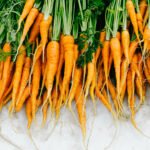 Revolutionize Your Fridge: The Simple Water Trick for Ever-Fresh Vegetables 4 Fresh vegetables like celery, asparagus, and carrots stored upright in glass jars with water in a refrigerator