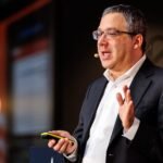 Portrait of Gary Marcus, a critic of AI hype, speaking at a conference.