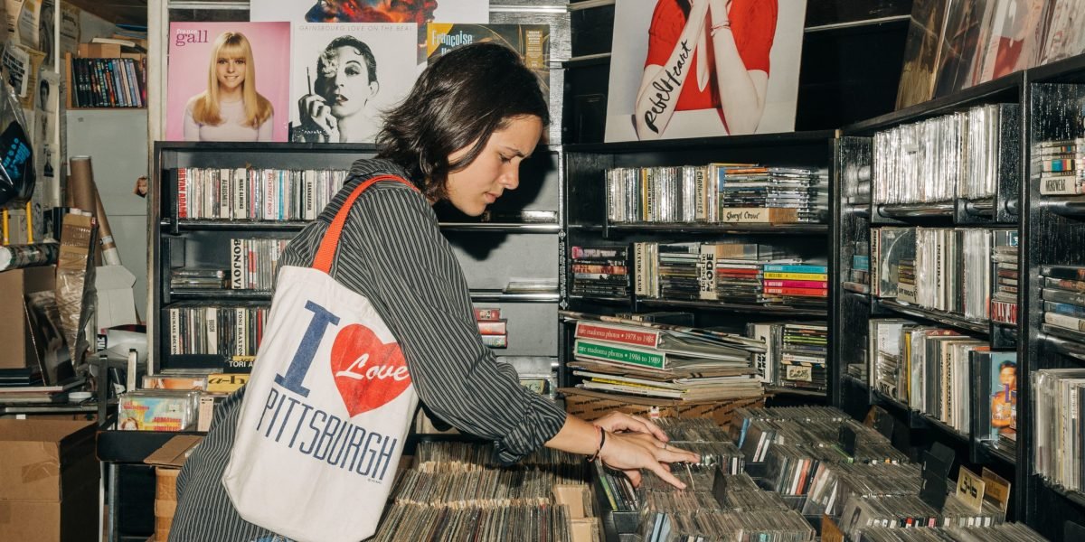 Gen Z's Tangible Rebellion: How Vinyl, Print, and Live Events Are Reshaping Youth Culture and Parental Wallets 3 A young person holding a vinyl record, surrounded by books and a record player.