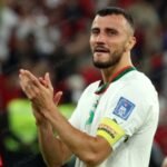 Ghanem Saïss, capitaine des Lions de l'Atlas, saluant les supporters après un match, symbolisant sa carrière et sa retraite internationale.
