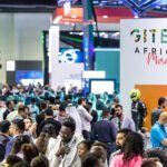 Vue panoramique de l'espace d'exposition du GITEX AFRICA à Marrakech, avec des participants interagissant et des stands technologiques.