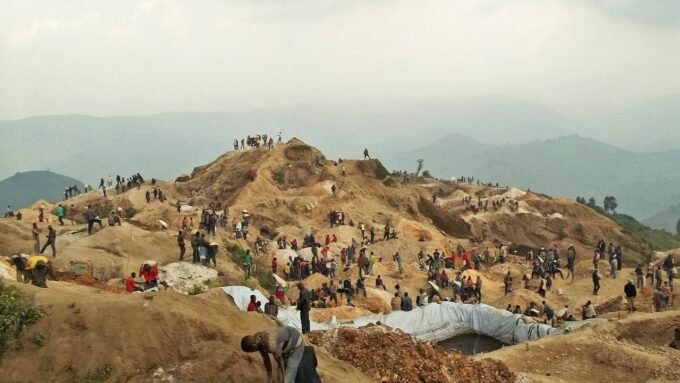 Vue aérienne de la mine de coltan de Rubaya en RDC, un site d'extraction à ciel ouvert avec des collines et des zones d'excavation.