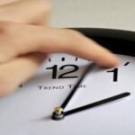 Horloge murale indiquant l'heure, avec un rappel de réglage des montres pour le passage à l'heure GMT au Maroc.