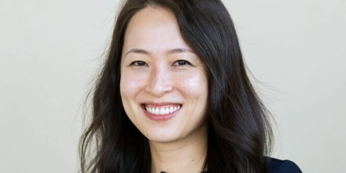 A professional woman, representing a JPMorgan banker, in a sleek office setting, with subtle imagery of skincare products or financial charts in the background.