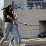 Hollywood industry figures reacting to a screen displaying AI-generated video, symbolizing the copyright and likeness concerns surrounding ByteDance's Seedance 2.0.