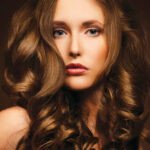 Gros plan sur une chevelure saine et brillante, symbolisant l'équilibre parfait entre hydratation et nutrition pour des cheveux sublimés.