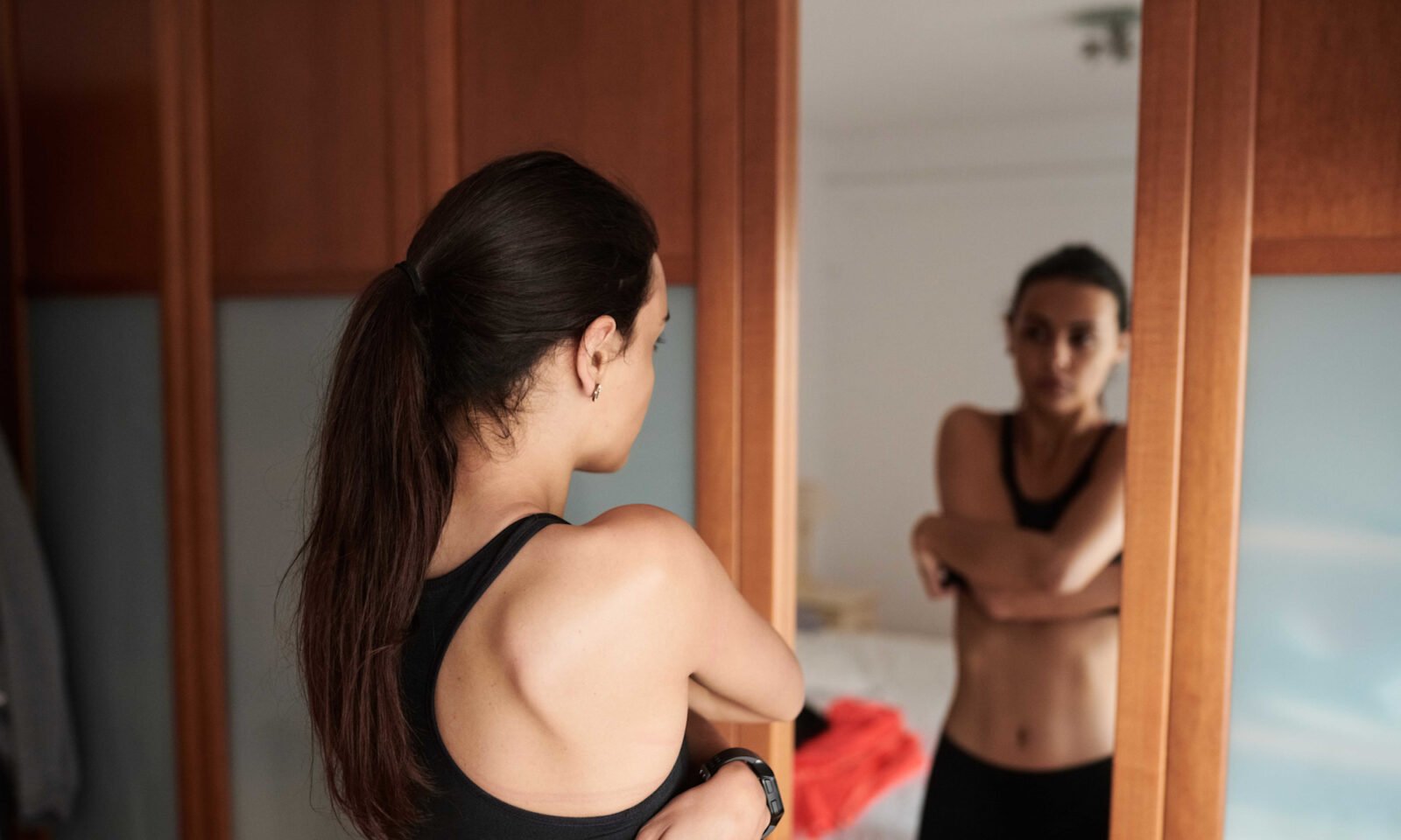 A person spraying hypochlorous acid mist on their face after a workout at the gym