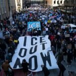 Protestors march with signs against ICE enforcement during a demonstration in Minneapolis, Minnesota.