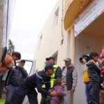 Une femme souriante, Fatima Zahra, devant un paysage urbain, symbolisant l'action humanitaire et la solidarité.