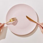 Intermittent Fasting: Is the Hype Over? A Major Study Challenges Its Weight Loss Claims 4 A person looking at a clock, symbolizing time-restricted eating or intermittent fasting.