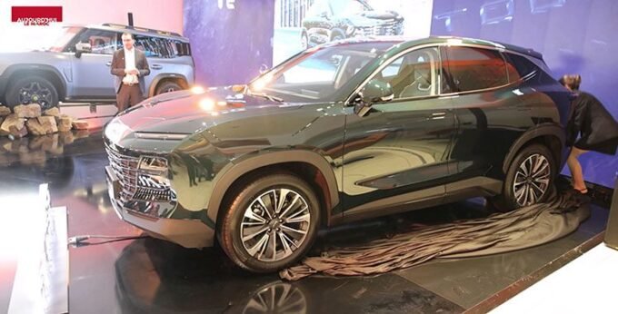 Un SUV Jetour T2 de couleur verte, au design robuste et moderne, est présenté lors de l'événement de lancement au Maroc. Le véhicule est mis en valeur sous un éclairage professionnel, avec des éléments de la marque Jetour visibles en arrière-plan.