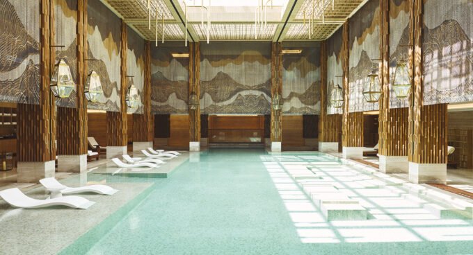 Une esthéticienne appliquant un soin Omorovicza sur le visage d'une cliente au luxueux Spa du Four Seasons Rabat, avec des produits de la marque en arrière-plan.