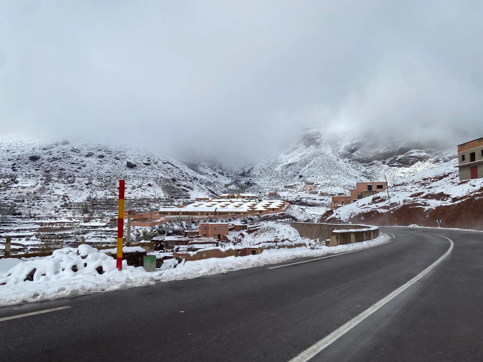 Paysage montagneux enneigé au Maroc sous un ciel menaçant, illustrant les conditions météorologiques extrêmes annoncées.